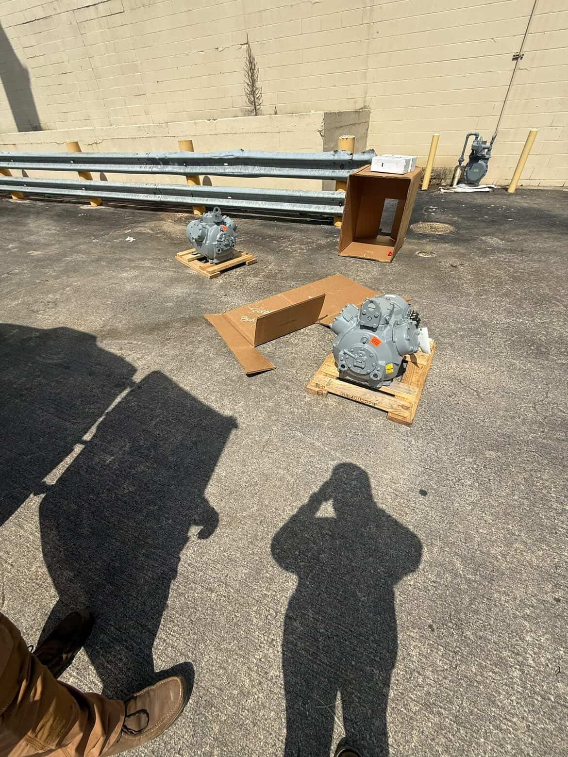 Ruben of HyperTemp HVAC on a job site with compressors staged for install